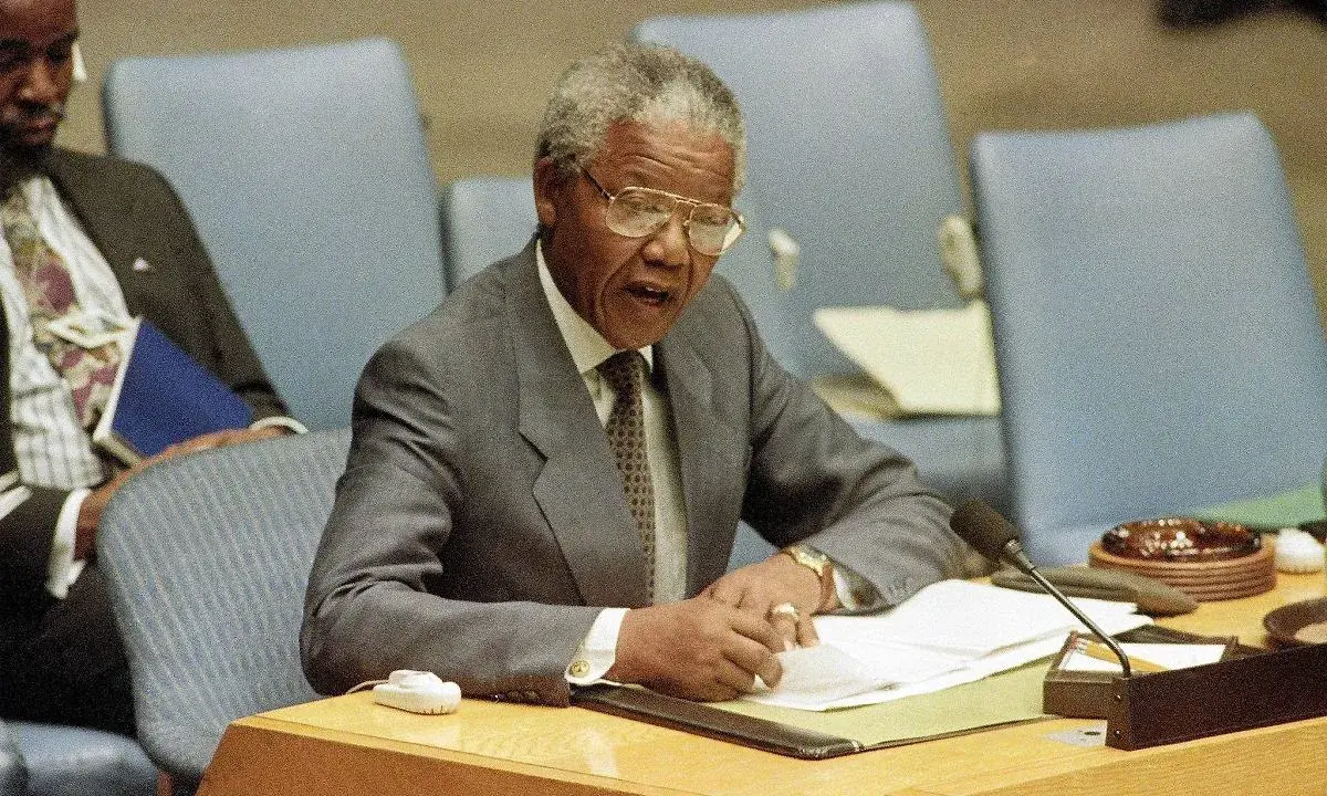 Nelson Mandela przemawia, pisząc notatki. Jego życie, a nie śmierć, jest tematem tej sceny.