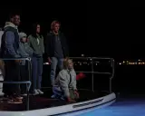 Na pokładzie łodzi nocą, grupa młodych ludzi w napięciu obserwuje coś w mroku. Czy ktos z nas kłamie?