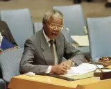 Nelson Mandela przemawia, pisząc notatki. Jego życie, a nie śmierć, jest tematem tej sceny.