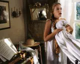 Młoda dziewczyna w białej sukni, białej jak śnieg w eposie, trzyma tkaninę. Obok fortepian z nutami i słomkowy kapelusz.