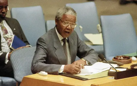 Nelson Mandela przemawia, pisząc notatki. Jego życie, a nie śmierć, jest tematem tej sceny.