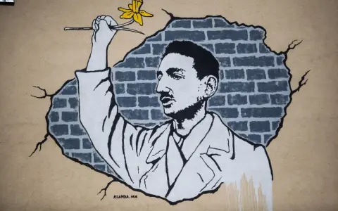 Mural przedstawia mężczyznę z żółtym kwiatem, który przebija się przez ceglaną ścianę. Jakby chciał zdążyć przed panem bogiem, by wręczyć mu ten symbol nadziei.