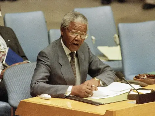 Nelson Mandela przemawia, pisząc notatki. Jego życie, a nie śmierć, jest tematem tej sceny.