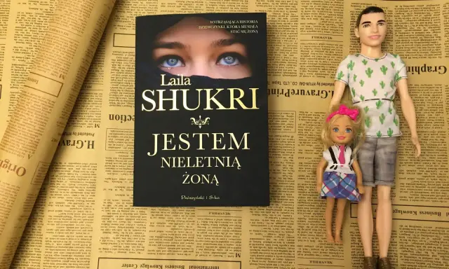 Okładka książki Laila Shukri "Jestem nieletnią żoną" na tle gazet. Obok lalki Ken i Barbie.