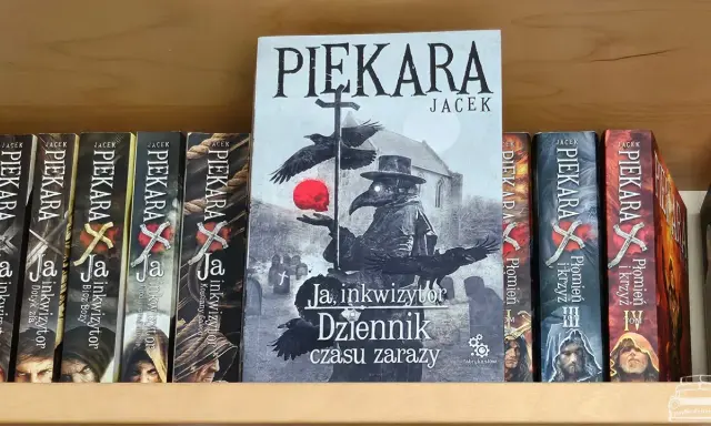 Książka "Ja, inkwizytor Dziennik czasu zarazy" Jacka Piekary na półce. Obok inne tomy serii.