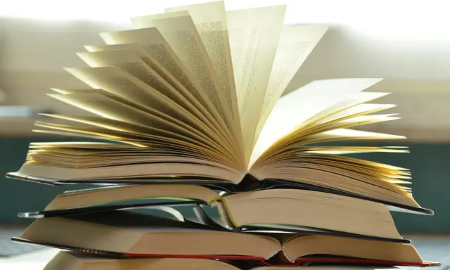 Stos otwartych książek, jakby opowiadał historię o tym, ile książek napisał Stephen King.